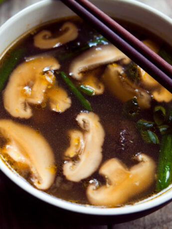 Bowl of Japanese miso soup with mushrooms and chopsticks.